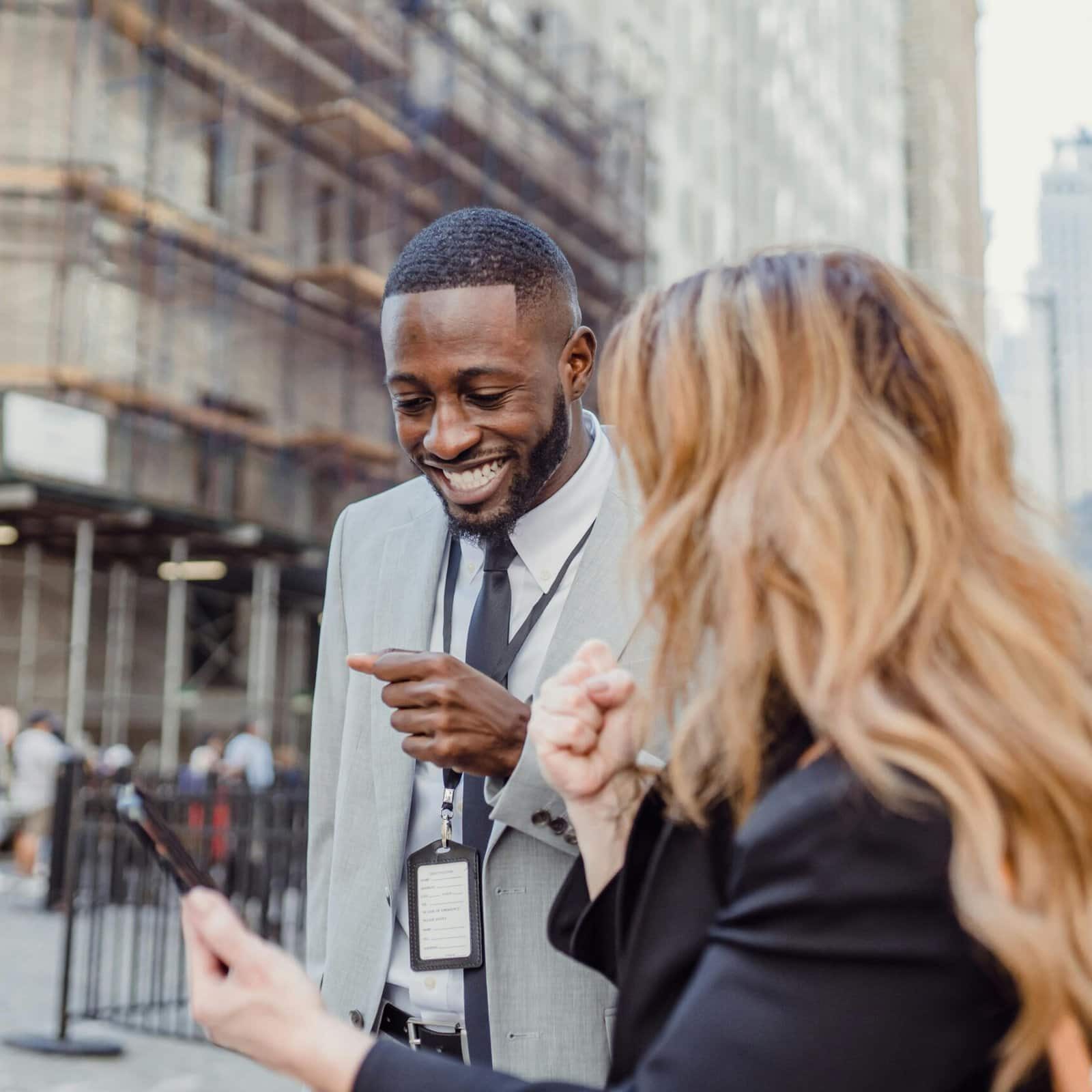 Two business professionals looking at prices on a mobile device