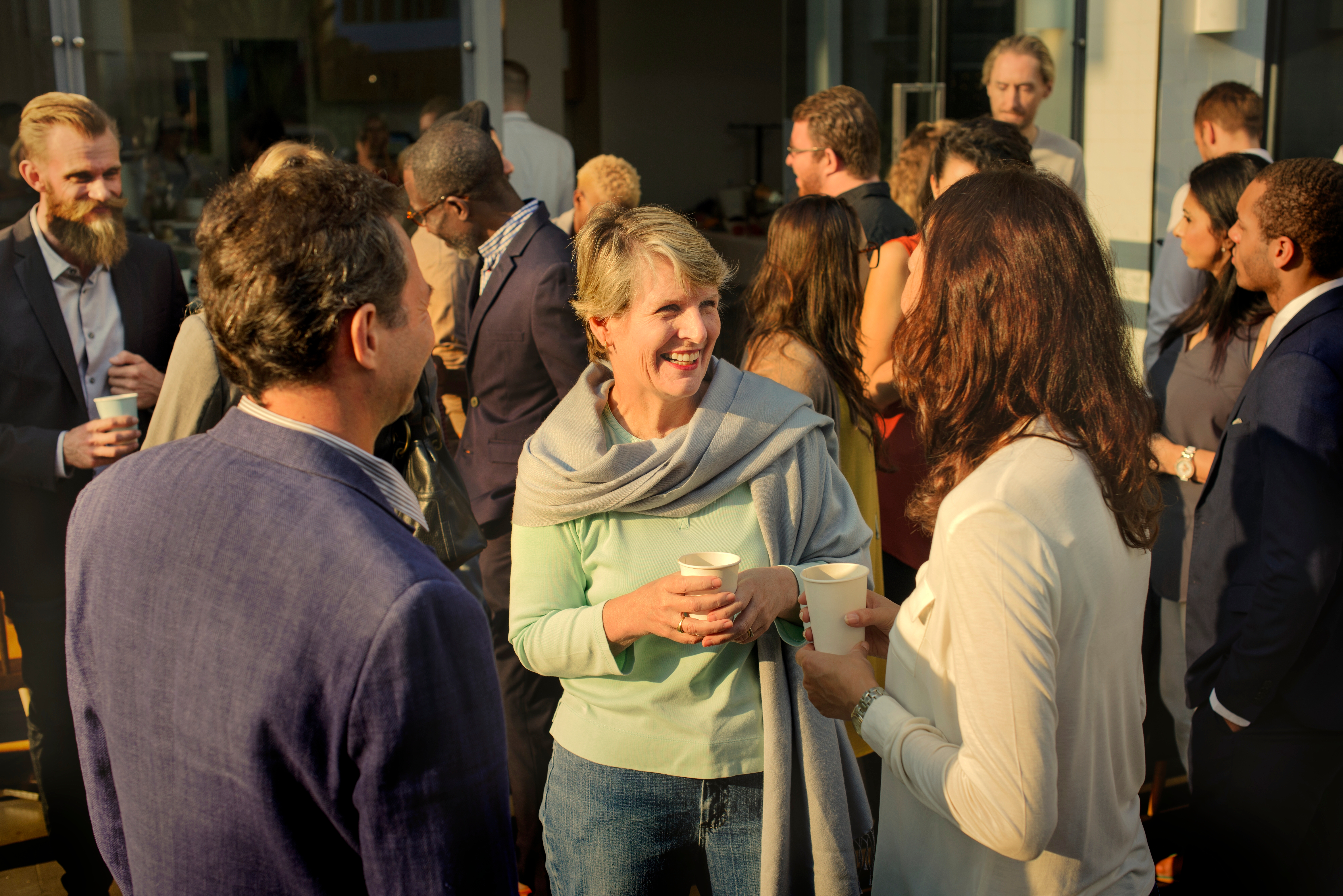 Smiling attendees chatting at an event during a networking break.